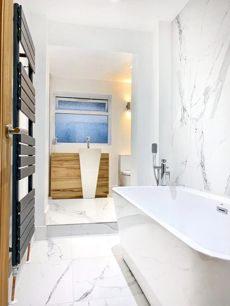 Modern marble bathroom with oak modern vanity and floor standing sink
