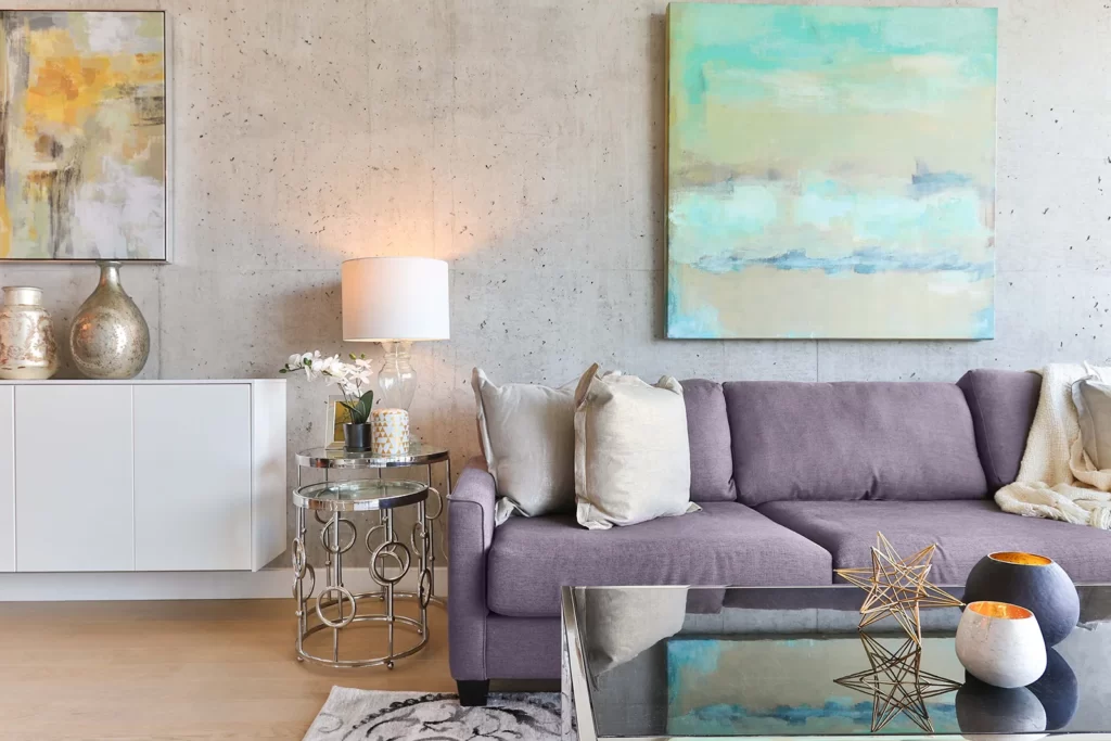 Living room with concrete wall, mauve sofa and chrome furniture
